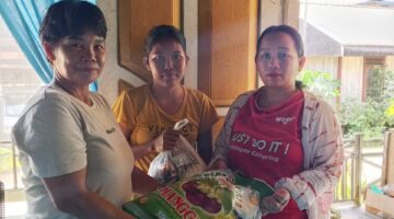 Kepala Adat Kampung Kliwai, Kecamatan Long Iram, Monika Ligit, saat menyalurkan bantuan sembako kepada warga yang membutuhkan sebagai wujud kepedulian dan kebersamaan.