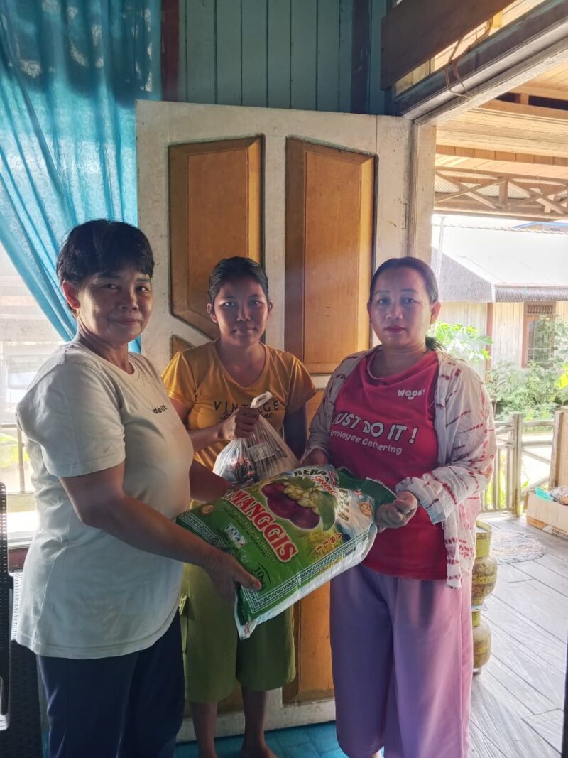 Kepala Adat Kampung Kliwai, Kecamatan Long Iram, Monika Ligit, saat menyalurkan bantuan sembako kepada warga yang membutuhkan sebagai wujud kepedulian dan kebersamaan.