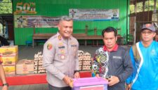 SERAHKAN BANTUAN: Kapolres Kutai Barat AKBP Haris Kurniawan, S.I.K., M.I.K. menyerahkan paket bantuan secara simbolis kepada Petinggi Kampung Muara Bunyut, Suhendi, saat meninjau lokasi terdampak tanah longsor di Kecamatan Melak, Jumat (7/8/2026).