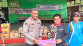 SERAHKAN BANTUAN: Kapolres Kutai Barat AKBP Haris Kurniawan, S.I.K., M.I.K. menyerahkan paket bantuan secara simbolis kepada Petinggi Kampung Muara Bunyut, Suhendi, saat meninjau lokasi terdampak tanah longsor di Kecamatan Melak, Jumat (7/8/2026).