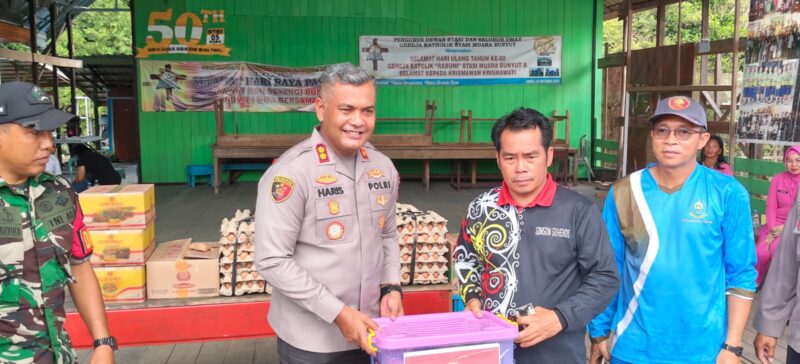 SERAHKAN BANTUAN: Kapolres Kutai Barat AKBP Haris Kurniawan, S.I.K., M.I.K. menyerahkan paket bantuan secara simbolis kepada Petinggi Kampung Muara Bunyut, Suhendi, saat meninjau lokasi terdampak tanah longsor di Kecamatan Melak, Jumat (7/8/2026).